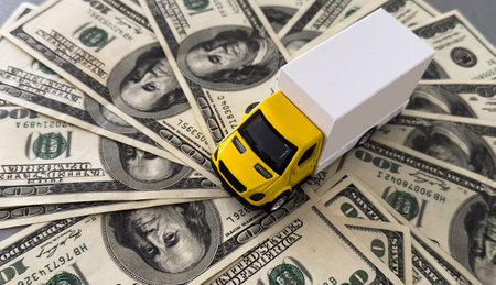 White toy truck lie on dollars, space for text.の写真素材