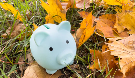 Piggy Bank in autumn leaves on the ground. Autumn background.の写真素材