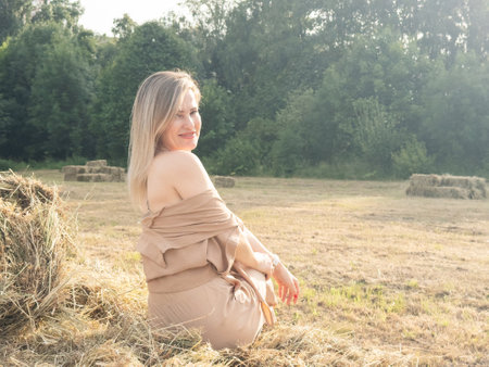 portrait of a beautiful girl on a wheat field during sunset.の写真素材