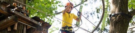 Brave kids climbs in rope park, playgroundの写真素材