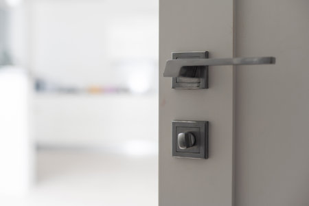 To open the door. Modern white door with chrome metal handle. Elements of interior closeupの写真素材