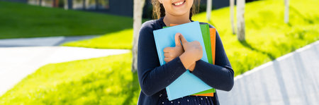 Little beautiful smiling girl holding book, going to school. close up portrait, isolated pink background, childhood. kid hugging a book. lifestyle, interest, hobby, free time, spare timeの写真素材
