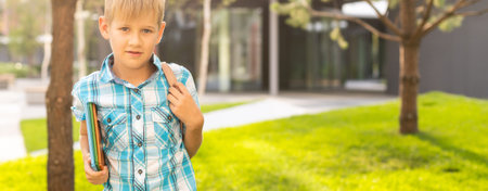 blond boy in t-shirt holding bookの写真素材