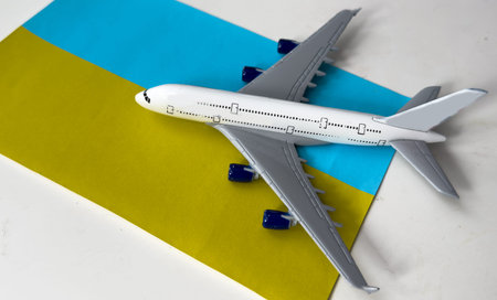Flag of Ukraine and model airplane. Resumption of flights after quarantine, opening borders. Travel...