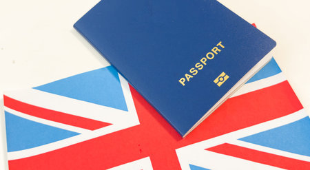Flag of United Kingdom with passport on background. Flight travel concept