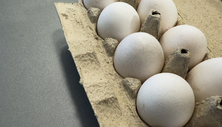 Fresh eggs in a recycled carton are perfect for breakfast or baking. This image showcases healthy,...
