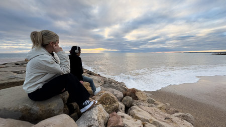 woman sitting on seaside and enjoying the sea view. Rear view. Copy space.
