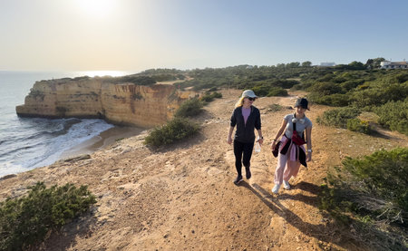 mother and daughter walking on the beach in the beautiful Algarve, Praia da Morena - Algarve - Portugalの写真素材