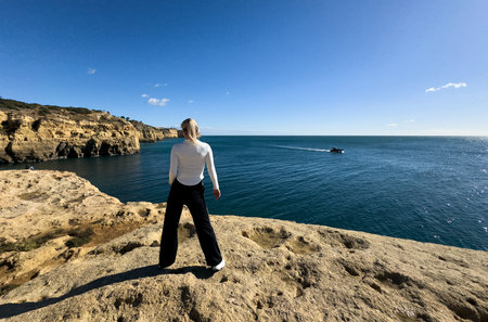 woman exercising by the sea on the Algar Seco walkway in Carvoeiro, Algarve, Portugal.の写真素材