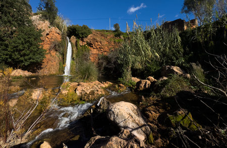 A waterfall in the heart of nature, a beautiful river and waterfall . The Queda do Vigario waterfall near Alte, Algarve, Portugalの写真素材