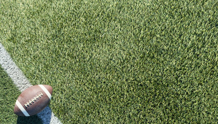 American football resting on a first down line during an American football game. The ball is ready...