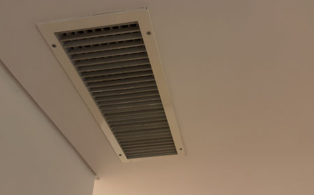 Ceiling with air conditioning vents and security cameras, creating modern interior atmosphere.