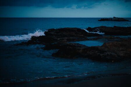 waves on the Mediterranean sea at night on the beachの写真素材