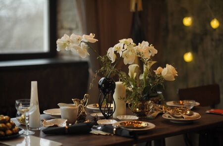 brown wooden table with beautiful plates and orchidsの写真素材