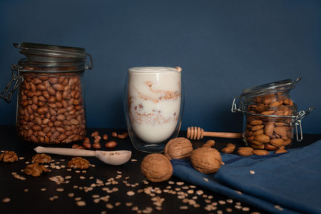 Yogurt with oatmeal and walnuts, almonds and peanuts with honey in a clear glass with double walls...