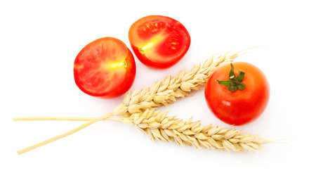 Tomatoes and ears of wheat isolated on white background.の写真素材