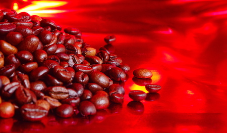 Coffee beans on red background. Brown coffee beans on red paper can be used as background.の写真素材