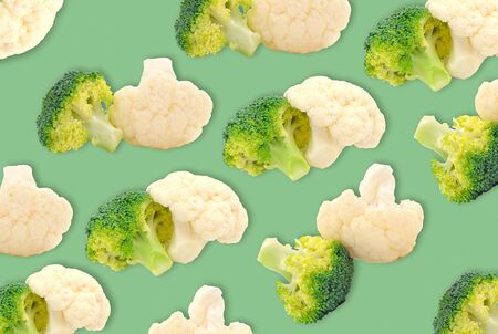 Fresh ripe broccoli piece and cauliflower cabbage vegetables on green background の写真素材