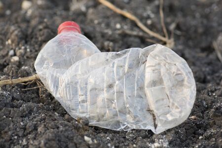 Environmental pollution: An empty plastic bottle of water, left as trash over the ground