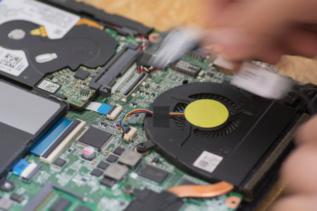 Technician repairing a laptop motherboard