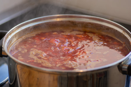 A boiling pot of traditional sour Borscht soup, one of the most famous dishes of Ukrainian cuisine, made with beetroots as one of the main ingredientsの写真素材