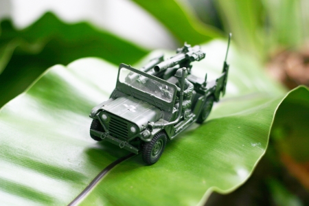 A toy soldier with jeep on his mission in the forest garden の写真素材