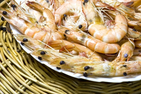 Close up boiled shrimp with shell on plate and basketの写真素材