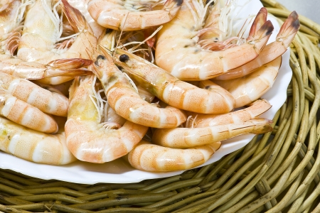 Close up boiled shrimp with shell on plate and basketの写真素材
