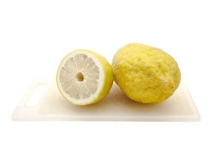 Half Japanese lemon on Cutting Board isolated on white backgroundの写真素材