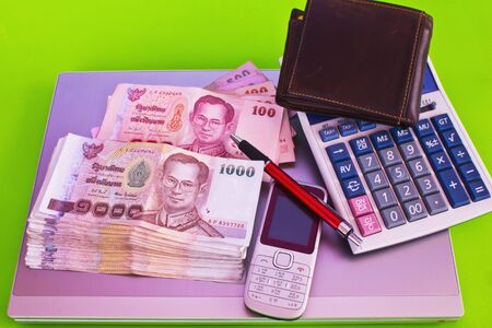  close up of 1000 baht banknotes and calculator on note bookの写真素材