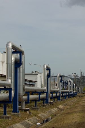 Stock Photo - Industrial zone, Steel pipelines and valves against blue skyの写真素材