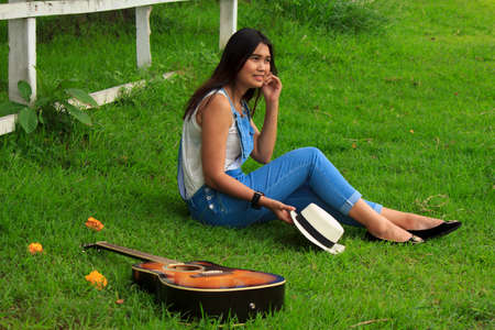 beautiful young country girl with a guitar on the woods  の写真素材