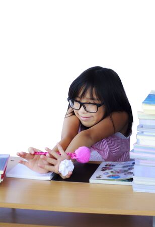 Stock Photo - Portrait of cheerful Asian young girl doing her homeworkの写真素材