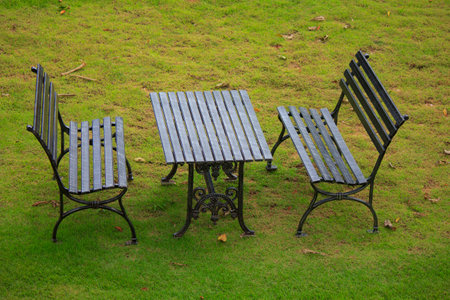 black shabby chic cast iron patio outdoor furniture set on grass lawn Stock Photo