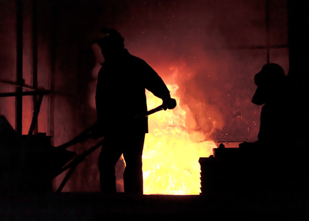 steel worker takes a sample from oven