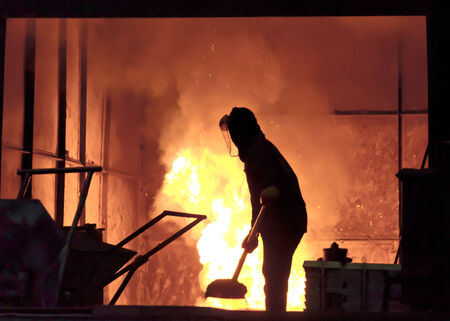 steel worker takes a sample from ovenの写真素材