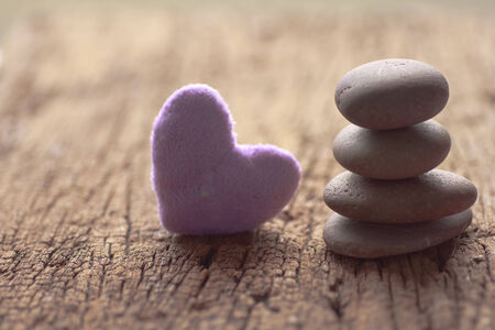 Zen stones and violet Heart on a wooden background, Love vintage conceptの写真素材