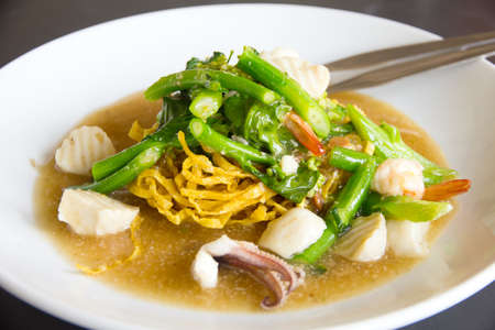 Fried noodle with pork and kale soaked in gravyの写真素材