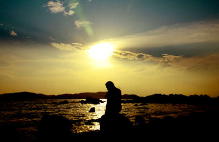 Twilight Scene. Sunset on the beach with a lonely girlの写真素材