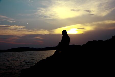 Twilight Scene. Sunset on the beach with a lonely girlの写真素材
