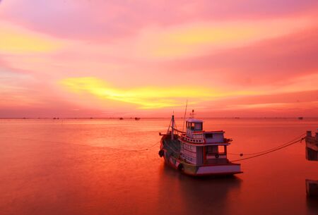 Silhouettes fishing boats at sea in sunsetの写真素材