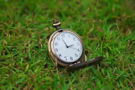Old vintage pocket clock on grass