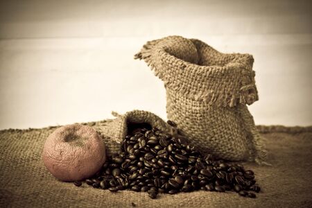 Cup of coffee with coffee beans  on sackcloth backgroundの写真素材