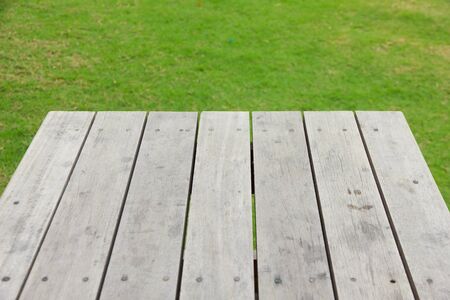 Green grass blurred background and old brown wooden floorの写真素材