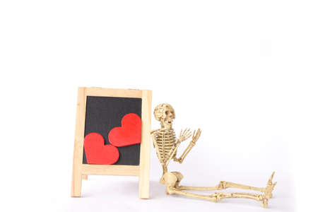 Red wooden heart on a wooden blackboard with Human Skeletonの写真素材