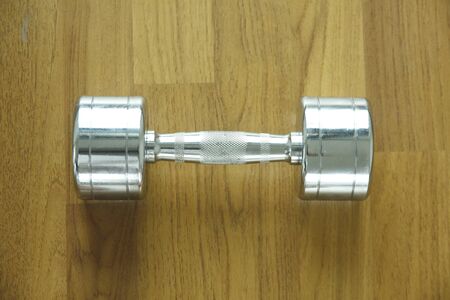 steel dumbell on the wooden floorの写真素材