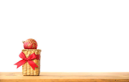 Christmas decorations in wicker basket on wooden tableの写真素材
