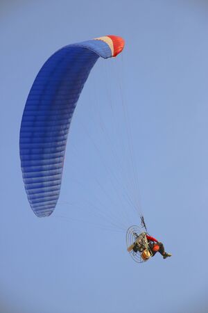 Paraglider on blue bright sky