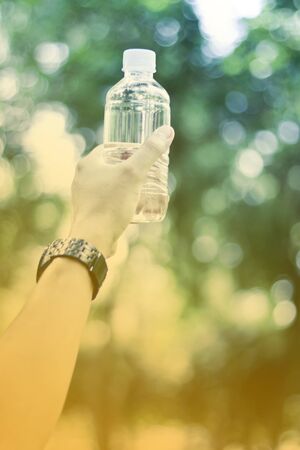 Man holding a bottle of water soft focus vintage styleの写真素材