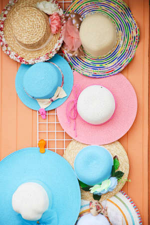 diverse straw hats hang up for saleの写真素材